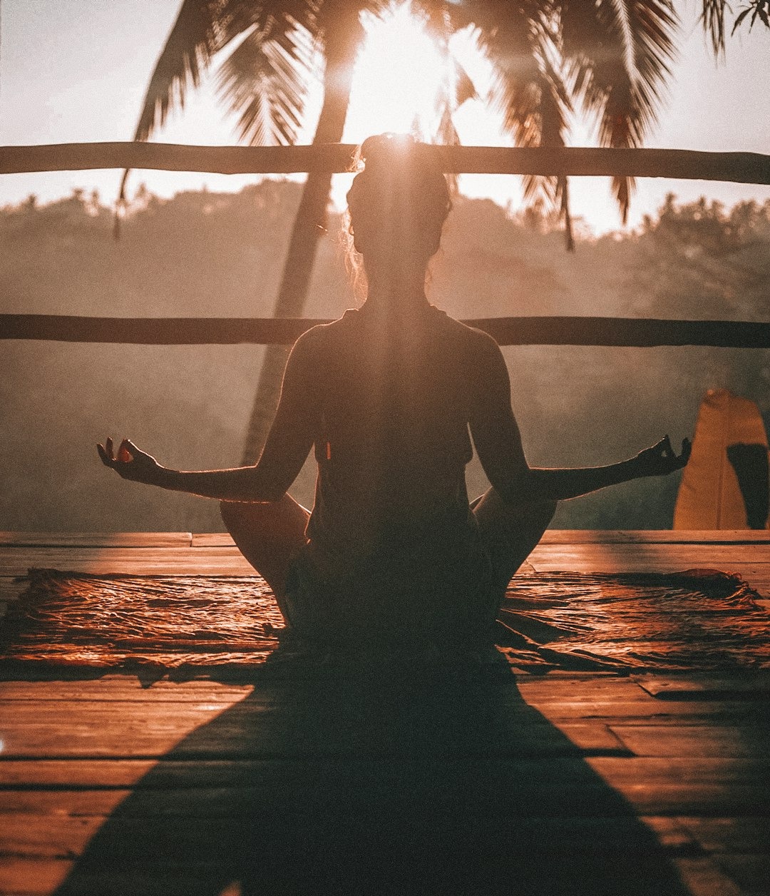 "Woman practicing sunrise meditation in nature to find balance and mindfulness in a fast-paced urban lifestyle"